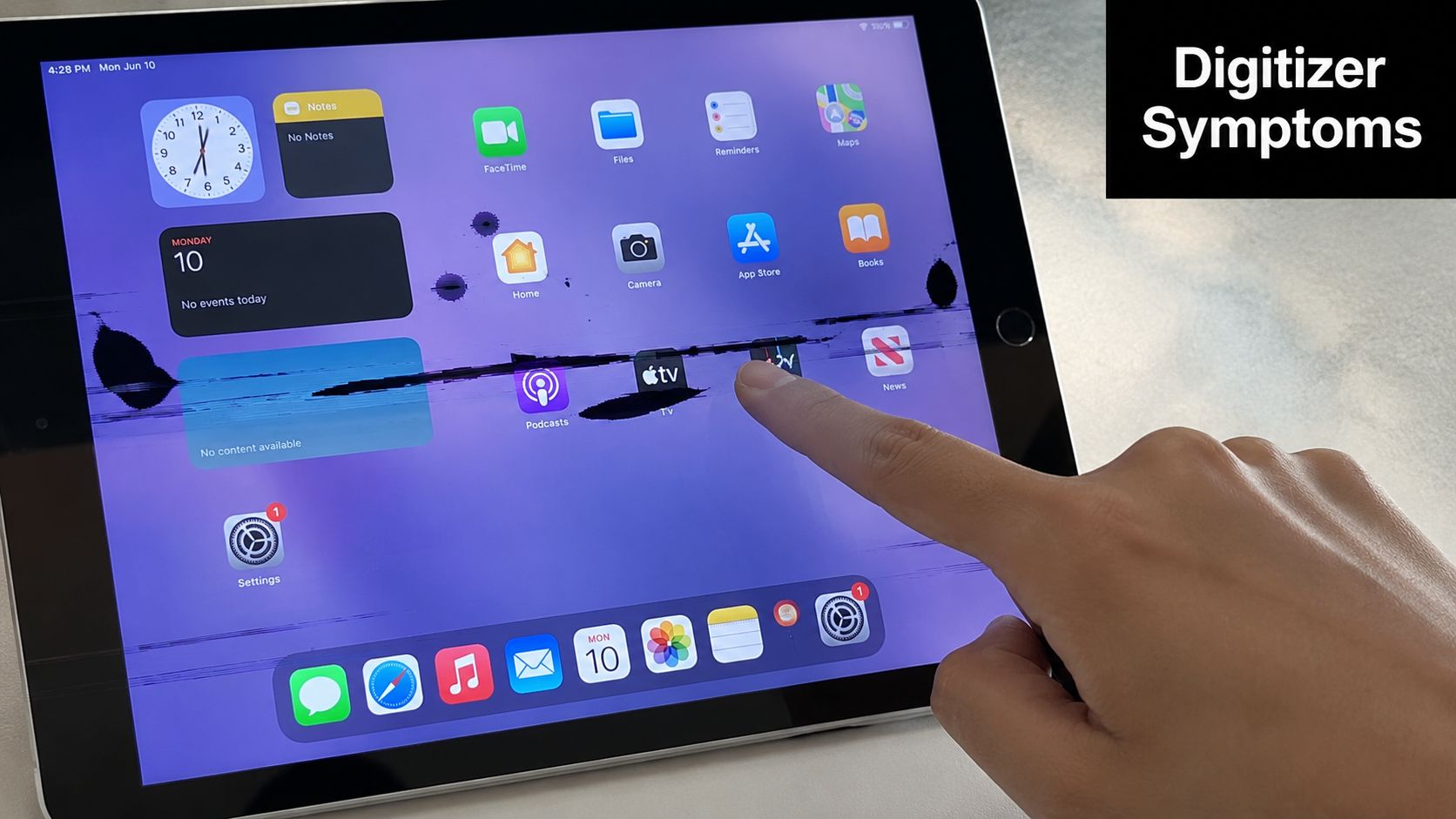 A hand touching a damaged iPad screen with prominent black ink-like spots indicating a faulty digitizer display.